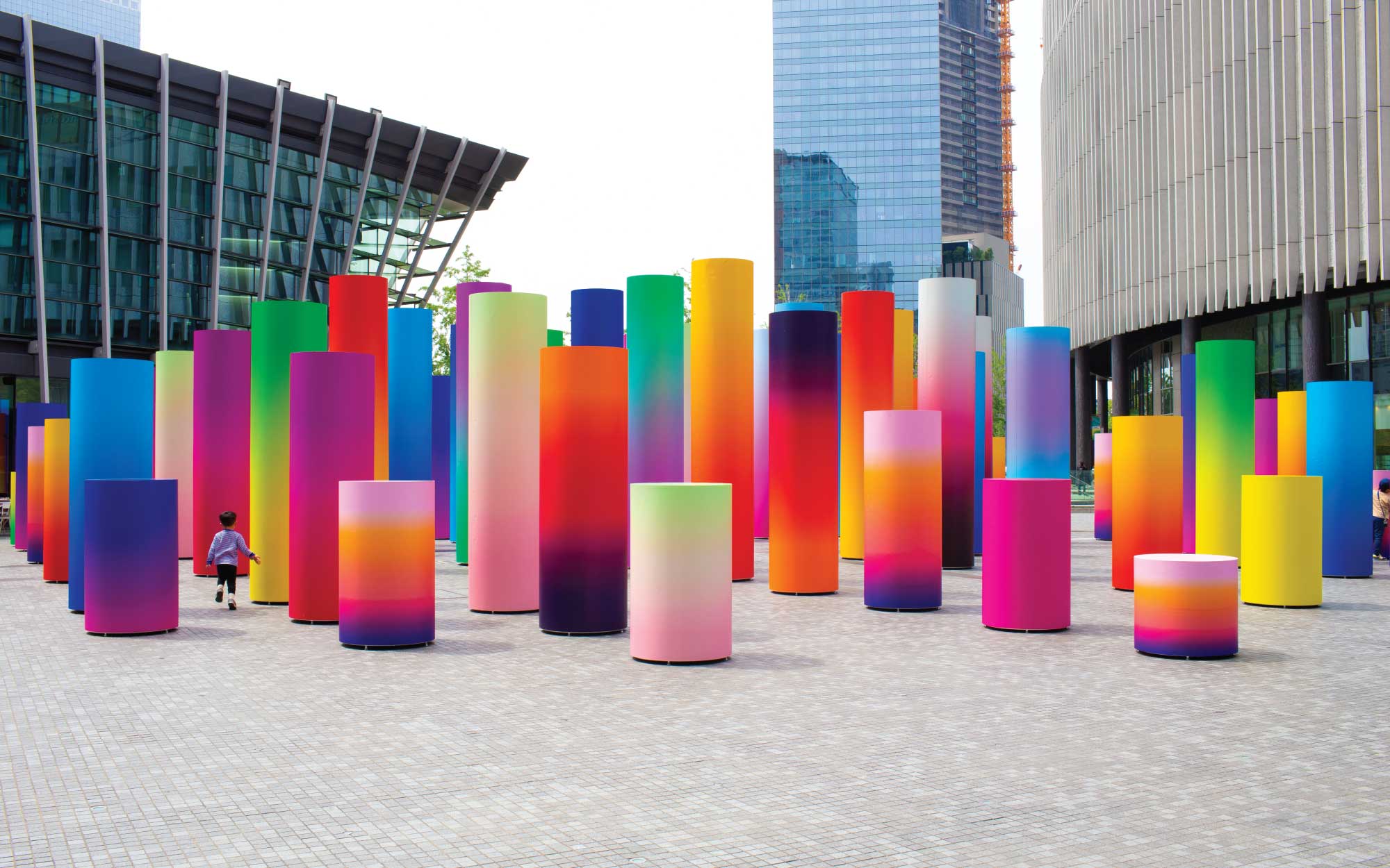 Designed by Adam Nathaniel Furman, this vibrant installation invites passersby to wander through a surreal forest of chromatic columns. (Image Credits: Adam Nathaniel Furman)