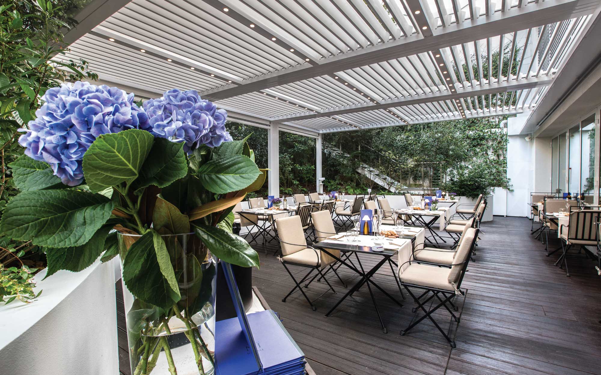 The restaurant overlooks and extends into the wonderful Secret Garden, a green lung rich in plants and shrubs that evoke fragrances and mark the seasons. (Image Credit: Magna Pars L’Hotel à Parfum ) 