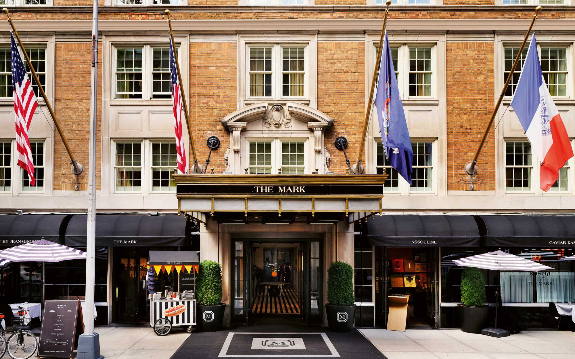 The Mark’s signature brick façade, framed by its awning and punctuated by the unmistakable striped flooring, offers a graphic prelude to the design language within. (Image Credits: Adrian Gaut)
