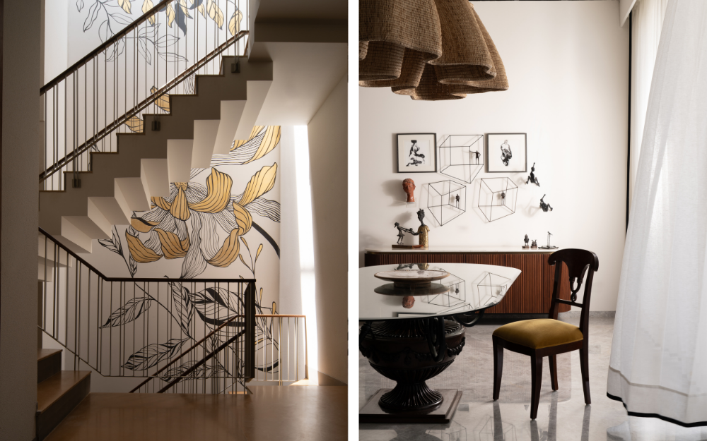 Left: Along the full height of the staircase, a hand-painted Tree of Life mural traces continuity across all four floors. Right: A statement light from Wicker Story crowns the dining zone, accompanied by artworks collected through the family’s travels over the years. (Image Credits: Avesh Gaur)
