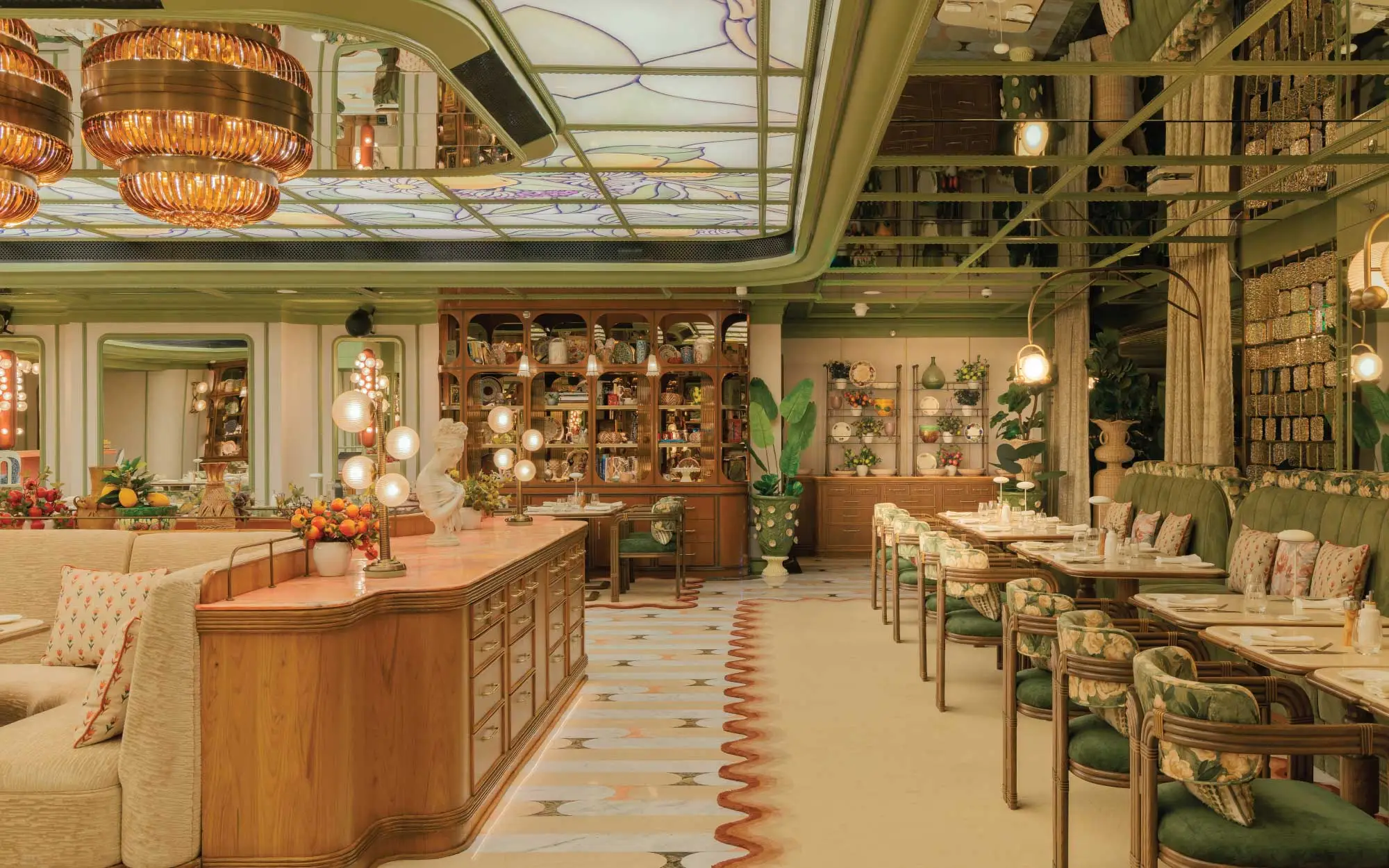 Fi’lia unfolds as a sprawling celebration of Italian conviviality. Rich wood tones and sun-washed lemon hues sweep across the upholstery and cabinetry, while curated displays of objects and curiosities lend the space a layered, lived-in charm. ( Image Credit: Roswyn - A Morgans Original Hotel) 