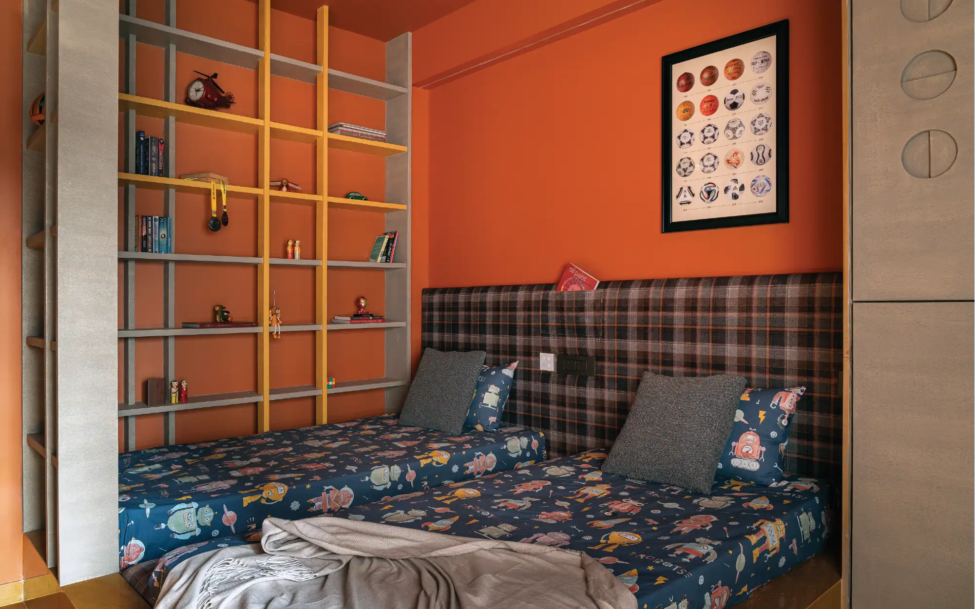 Left: A low-level bed wrapped in Jaisalmer stone flooring lends the compact room a greater sense of openness. Right: In the kids’ bedroom, terracotta walls and ceilings are paired with yellow Jaisalmer stone flooring to create a cocoon-like retreat, while custom millwork integrates storage, study and play. (Image Credits: Yash R Jain)
