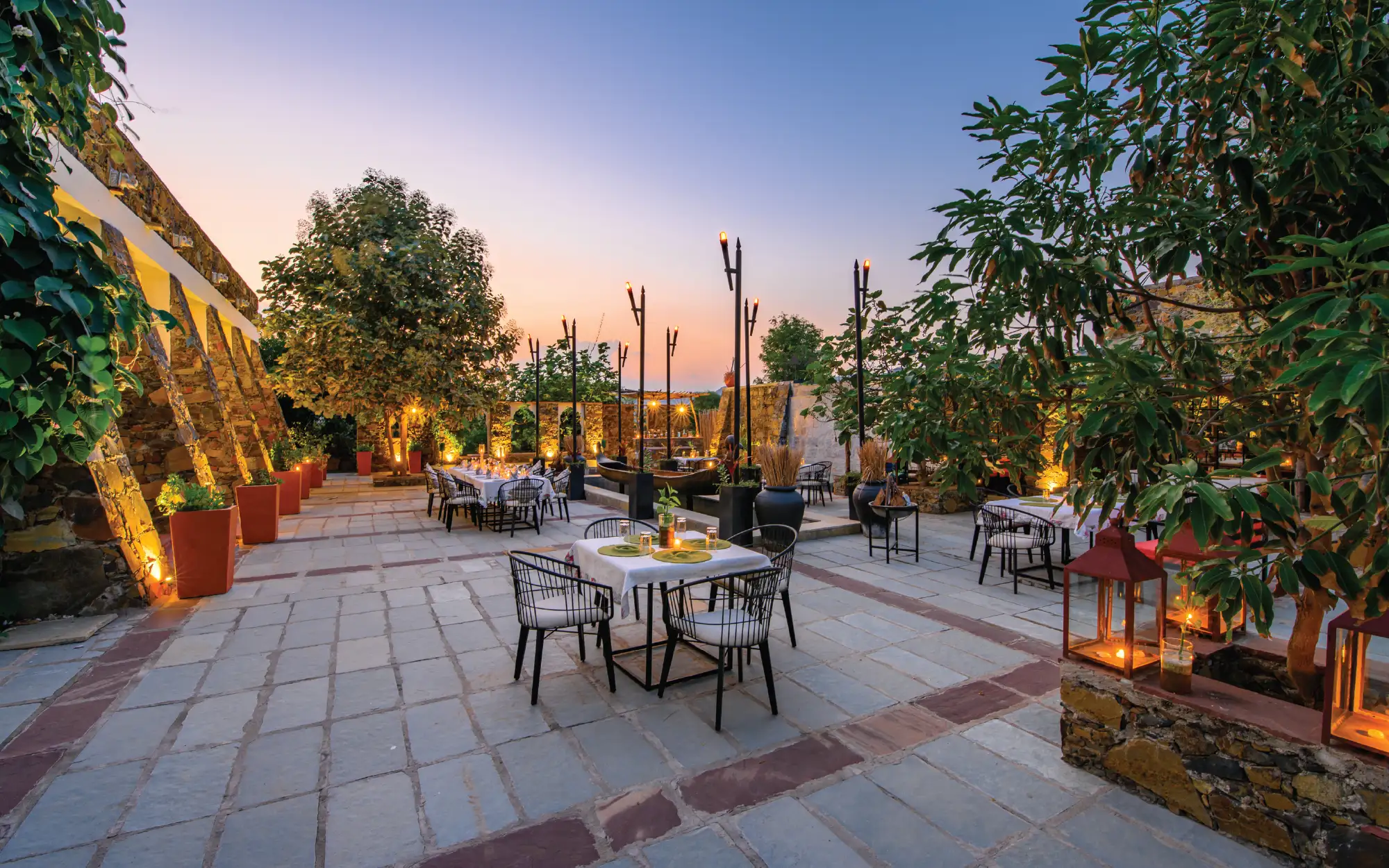 Courtyard dining unfolds beneath open skies, where seasonal fare and the quiet rhythms of the forest elevate every meal. (Image Credits: Utsav Camp)