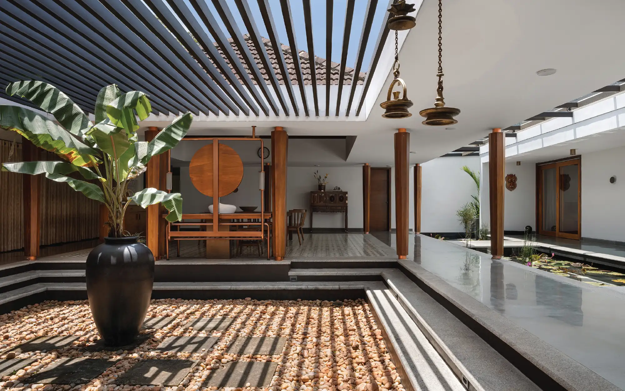 An intriguing interplay is created by juxtaposed volumes topped with pitched roofs around the central nucleus, the courtyard, connected by corridors under a single flat roof. (Image Credits: Justin Sebastian)