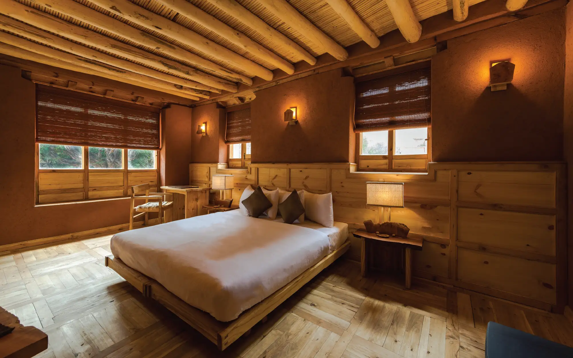 Inspired by the earthy hues of the landscape, the brown-and-ochre interiors are rooted in Ladakhi vernacular, while orchard views bring a sense of calm to every room. (Image credit: Chulli Bagh)