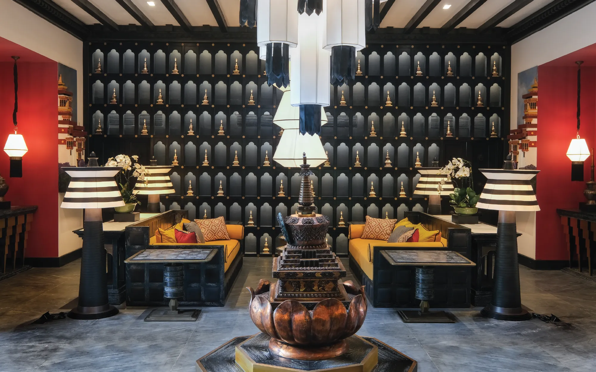 One of the lobby's most striking features is its dramatic charcoal-black wall. Against this dark canvas, Bhutanese stupas and sacred motifs emerge almost like works of ceremonial art, celebrating the spiritual symbolism. (Image Credit: Pemako Bhutan)
