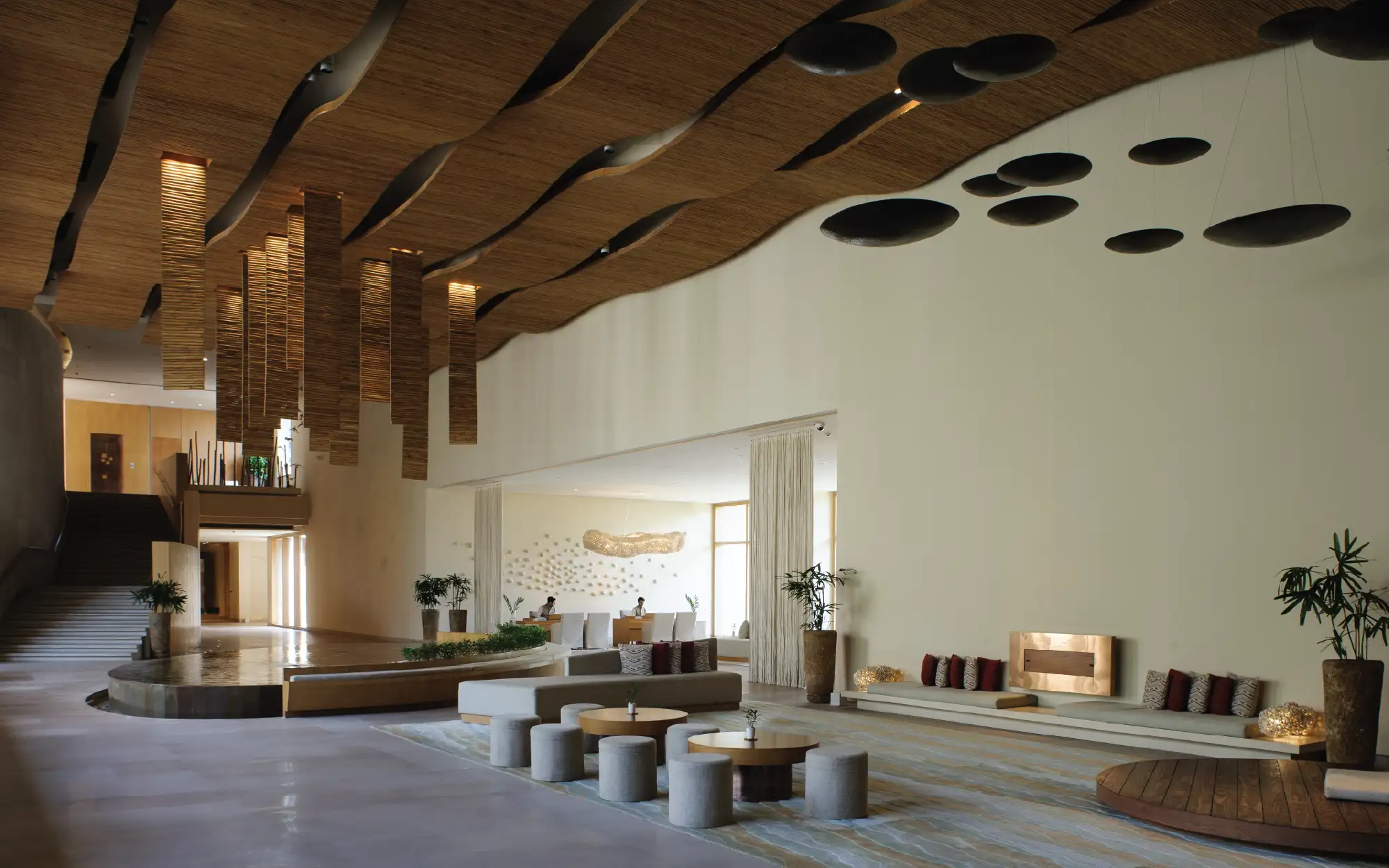 A sprawling foyer with bamboo ceiling and wooden accents, that set the tone for the sequence of spaces to come. (Image Credits: Jean-Marie del Moral)