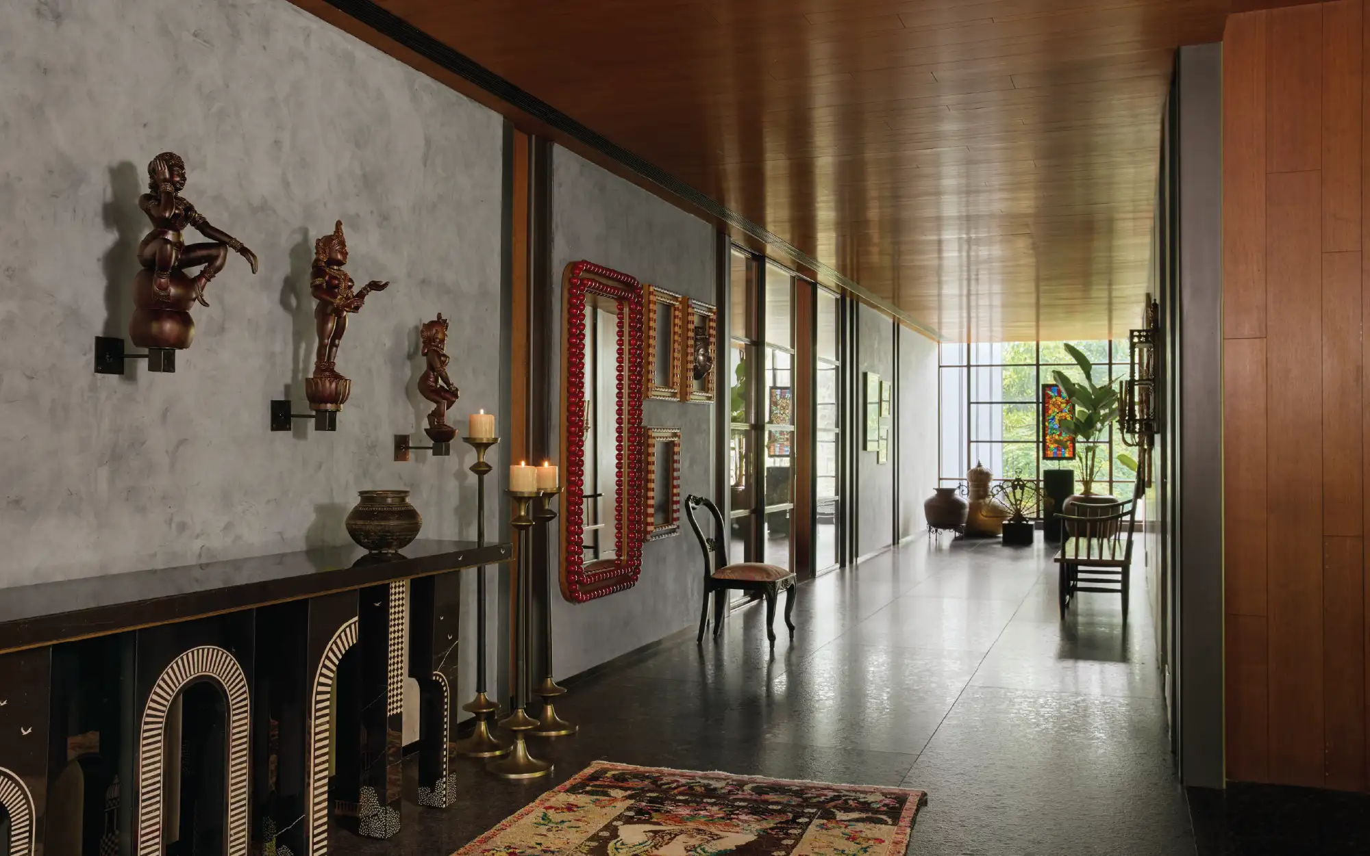 The first floor landing space is a fitting repository for the homeowner's sculptural dancing figures which have been personally collected by them. The space also features a vintage rug from Jaipur Rugs, candlestands from Studio Orion and a statement console by WITHIN (Image Credits: Talib Chitalwala, Styling Credit: Samir Wadekar)