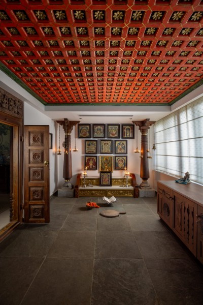 Recycled wood coffers hand-painted in lacquered crimson crown the pooja room